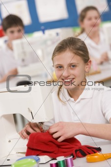 Schoolgirl using a sewing machine in sewing class