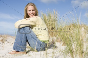 Young woman sitting amongst dunes