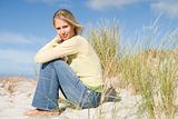 Young woman sitting amongst dunes