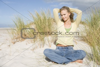 Young woman relaxing amongst dunes