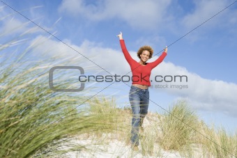 Young woman stretching amongst dunes