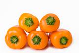 five orange bell peppers on white background
