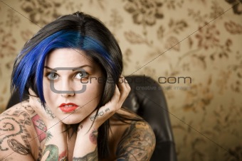 Pretty Woman with Tattoos in a Leather Chair