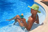 Woman enjoying a fresh cocktail in a blue pool