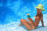 Woman enjoying a fresh cocktail in a blue pool