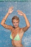 Young beautiful happy smiling tanned blond woman in bikini at rain or summer shower on sea beach