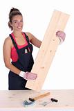 woman carpenter holding wooden plank 