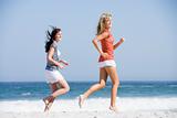 Two women running along beach