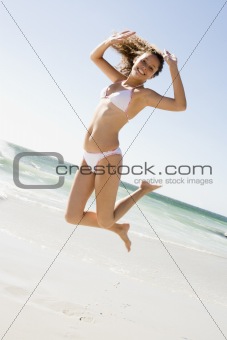 Woman leaping on beach