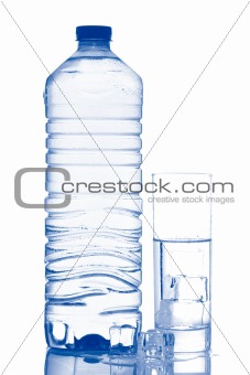 Bottle and glass of mineral water with ice cubes