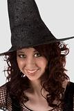 Dark portrait: smiling teen girl in Halloween hat
