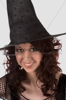 Dark portrait: smiling teen girl in Halloween hat