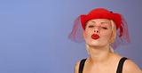 blond pin-up in hat blowing a kiss - space for text