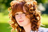Bright portrait of red-haired young woman outdoors