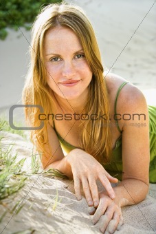Woman relaxing on sand.