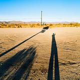 Man's long shadow in desert.
