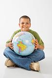 Smiling hispanic boy holding globe.