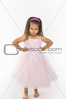Little girl wearing pink dress pouting.