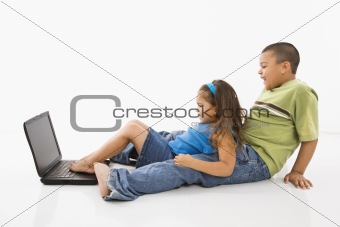 Hispanic boy and girl on laptop.