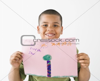 Smiling hispanic boy holding drawing.