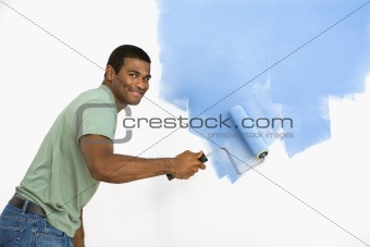 Handsome man painting wall.