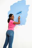 Pretty woman painting wall.