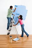 Couple painting wall blue.