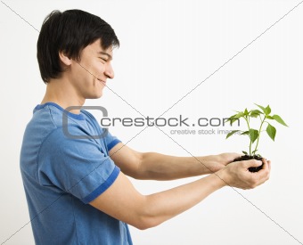 Man holding plant.