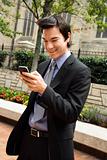 Businessman smiling at cell phone message.
