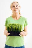 Woman holding potted grass.