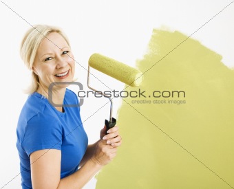 Woman painting wall.