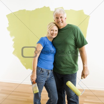 Man and woman with half-painted wall.