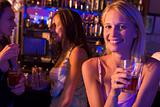 Three young women enjoying drinks at a nightclub
