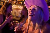 Young woman in cowboy hat laughing at a nightclub