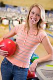 Young woman holding a bowling ball in a bowling alley