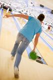 Man bowling, rear view (blurred motion)