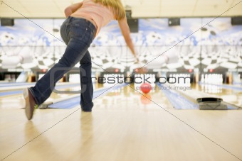 Woman bowling, rear view