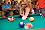 Young woman playing pool in a bar