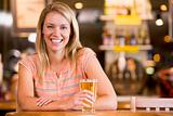 Young woman enjoying a beer at a bar 