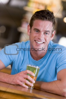 Young man enjoying a beer at a bar 