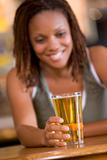 Young woman enjoying a beer at a bar 