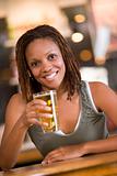 Young woman relaxing with a beer at a bar 