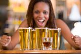 Young woman staring excitedly at a round of beers