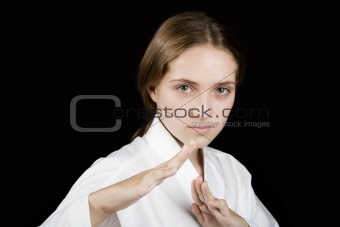 Young girl in a karate pose on black