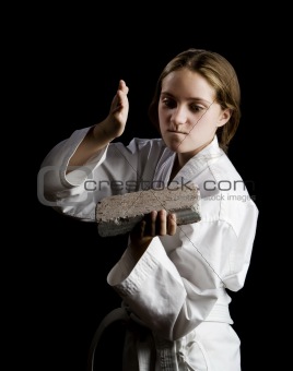 Young girl karate chopping a brick