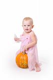 smiling little girl embraces a pumpkin