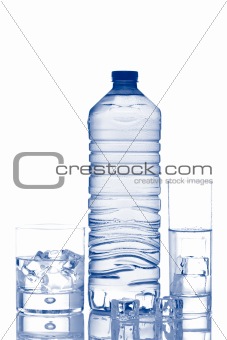 Bottle and glasses of mineral water with ice cubes