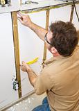 Electrician Installs Wiring in Wall