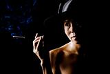 Woman in shadow wearing a black hat with cigarette