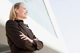 Businesswoman standing outdoors by building smiling